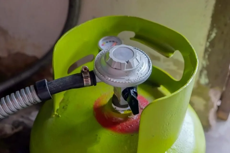 Green propane cylinder with regulator and hose connection