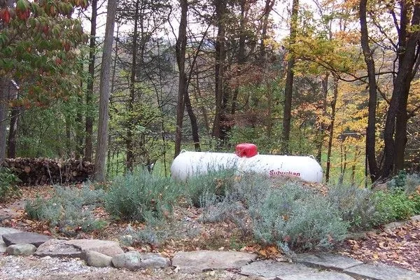 Residential propane tank beside a home used as a Get Propane Refill policy banner