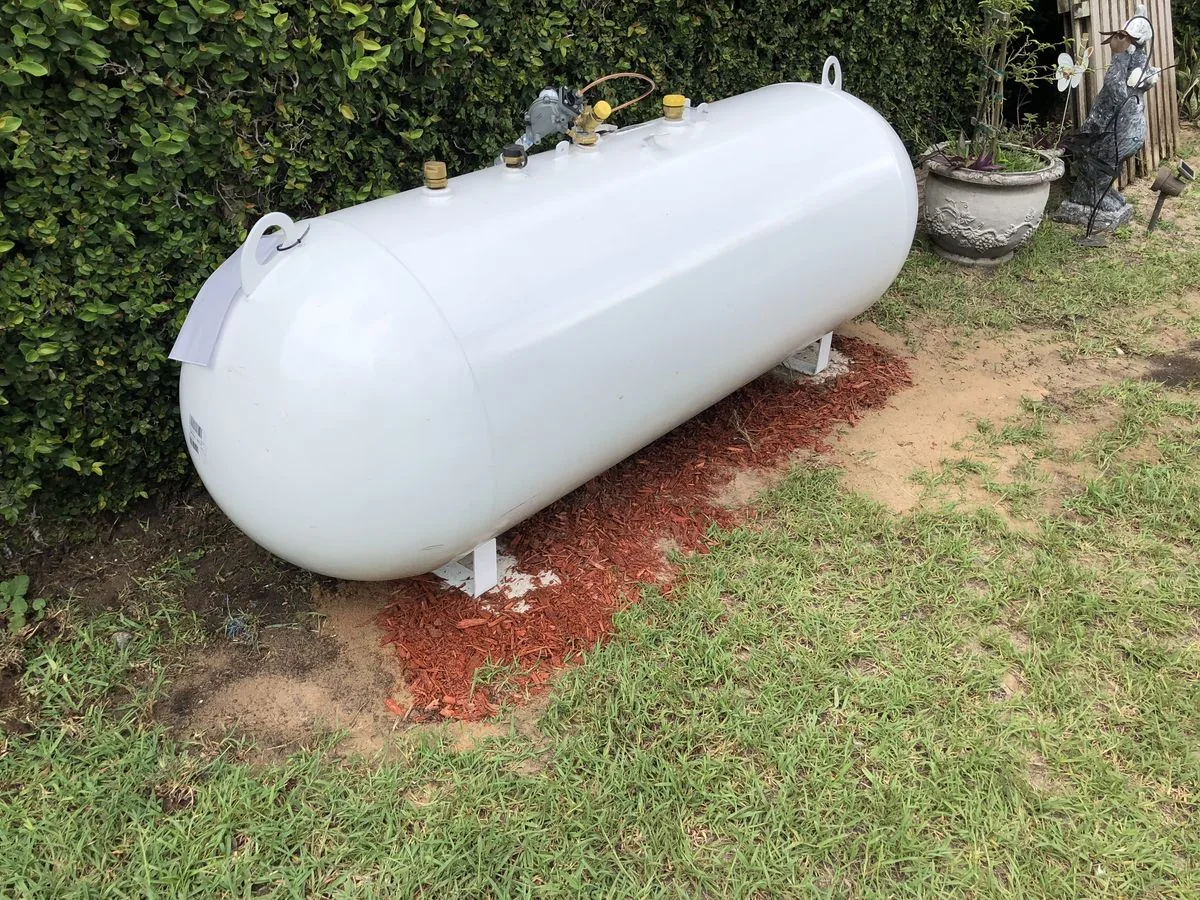 White residential propane tank installed outdoors