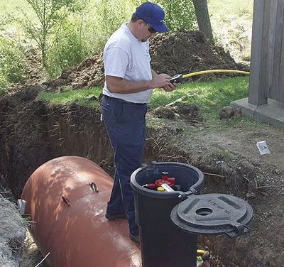 Propane tank installation work at a landscaped property