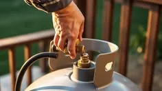Hand operating a propane tank valve