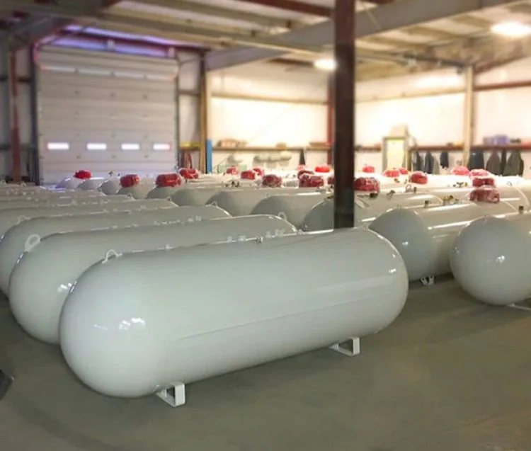 Rows of horizontal propane tanks stored inside a warehouse
